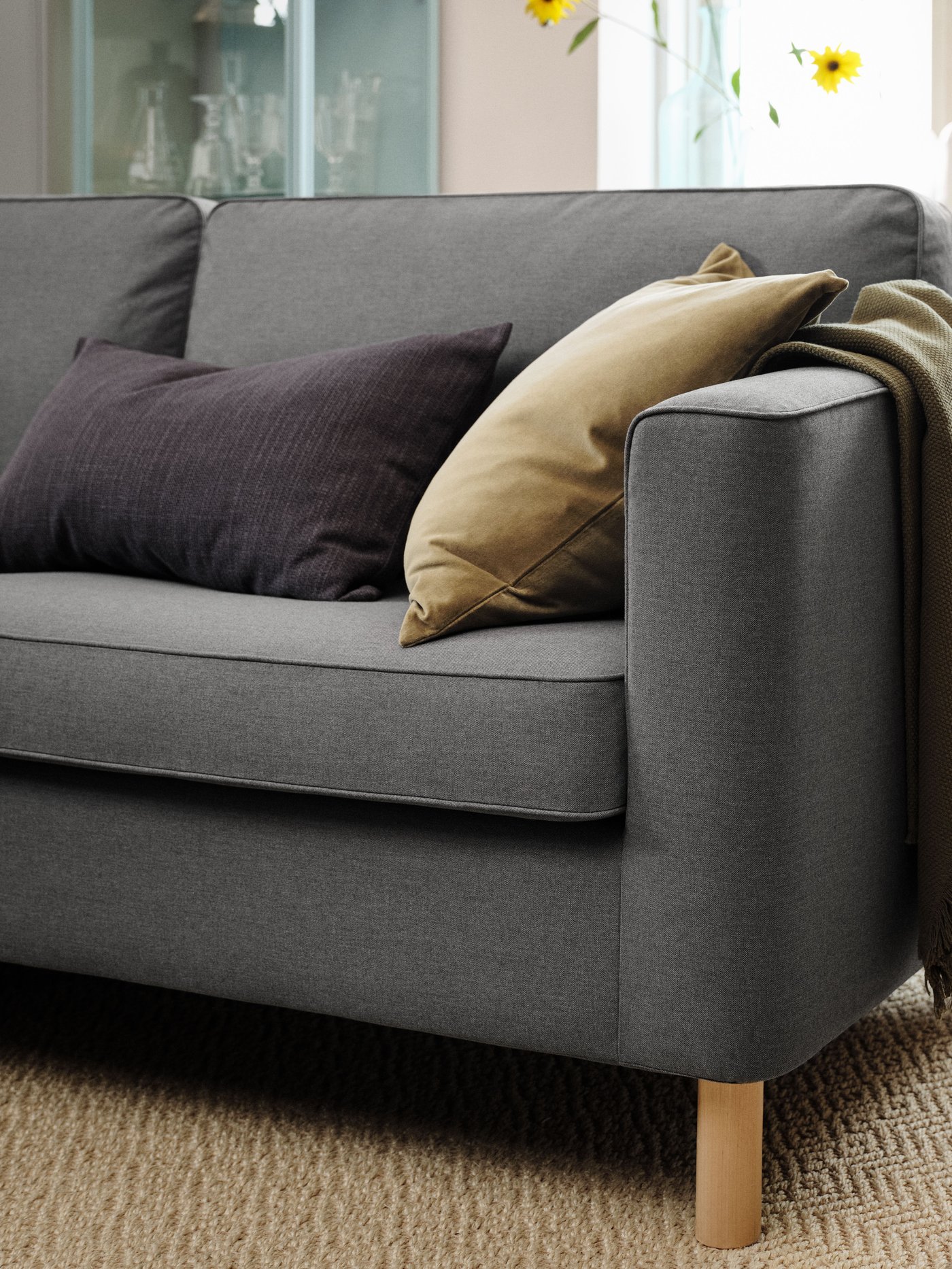 A close-up of a grey PÄRUP sofa with a couple of pillows