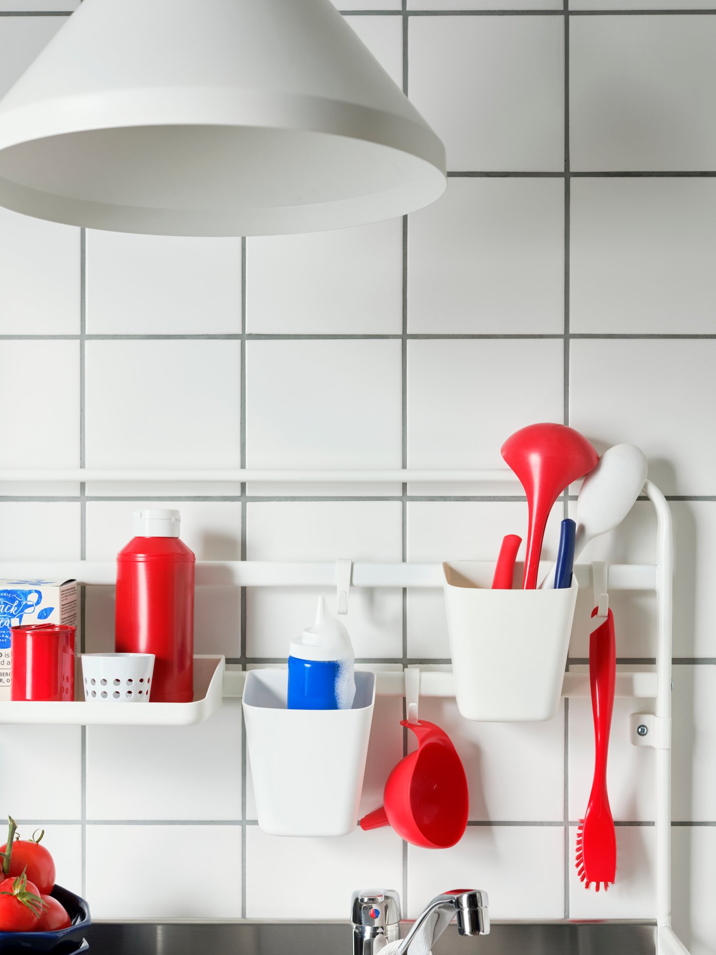 White SUNNERSTA hooks, containers and shelf with red, blue and white kitchen items hanging on a SUNNERSTA mini-kitchen rail.