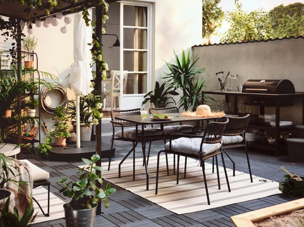 An outdoor dining area setup with VIRKLUND low pile rug
