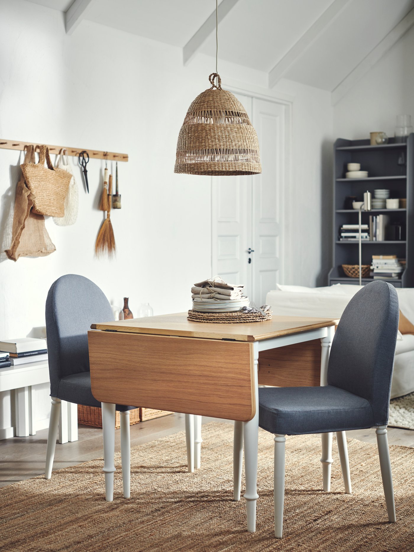 An airy, light room with a DANDERYD drop-leaf table and two grey-and-white DANDERYD chairs beneath a TORARED sedge pendant.