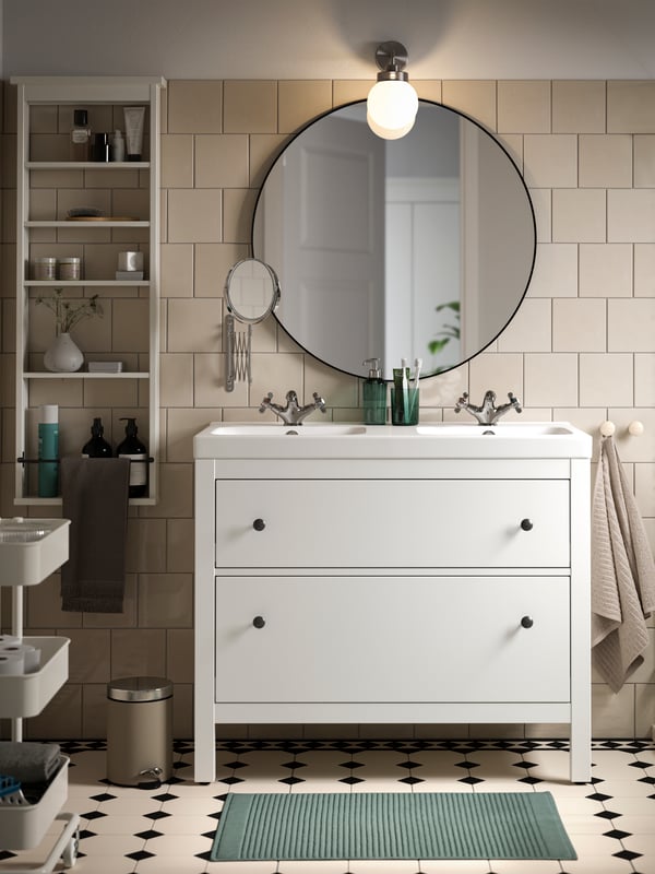 A bathroom with a HEMNES wash stand with two drawers in white and an ODENSVIK wash basin and a LINDBYN mirror in black.