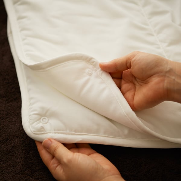 Une couette à deux couches combinables à l’aide de boutons-pressions
