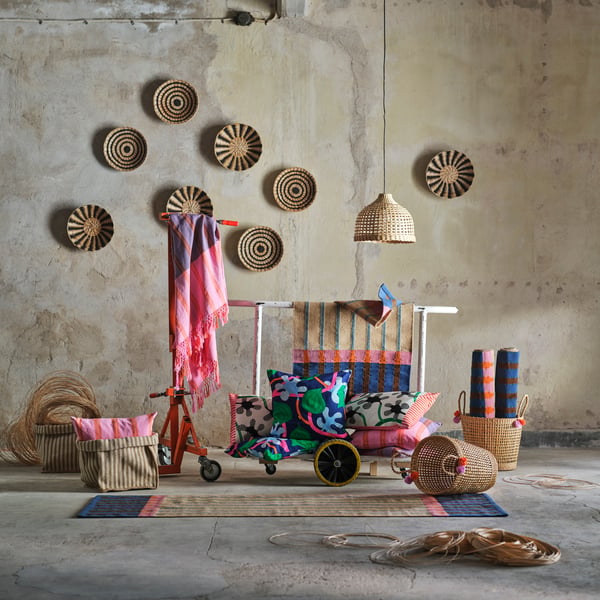 The MÄVINN collection displayed in an industrial-looking space. The natural fibres blend with pink, green and blue textiles.