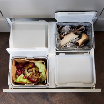 Organised kitchen drawer with recycling bins and a food-waste container.				