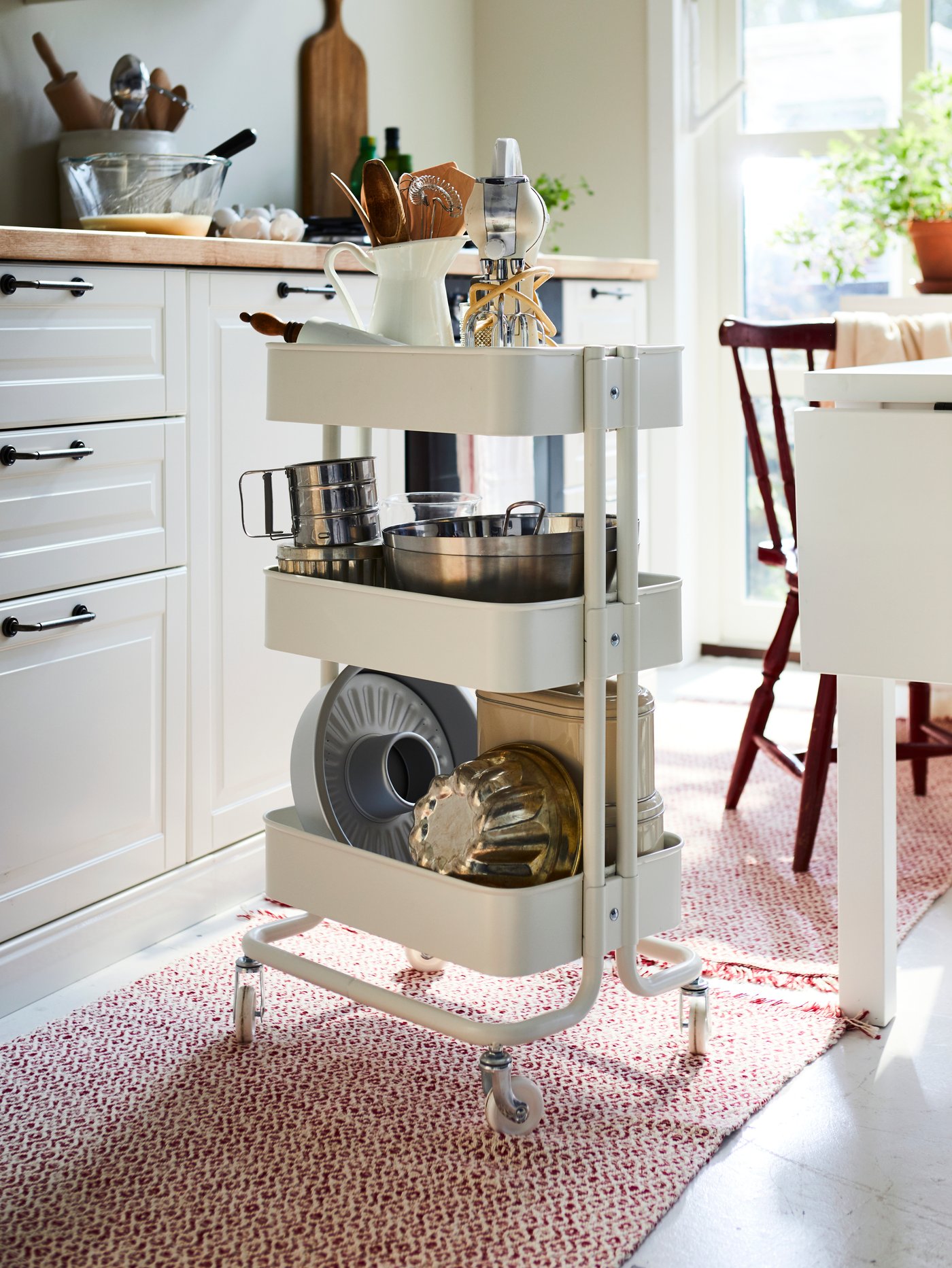 A white RÅSKOG trolley in the kitchen
