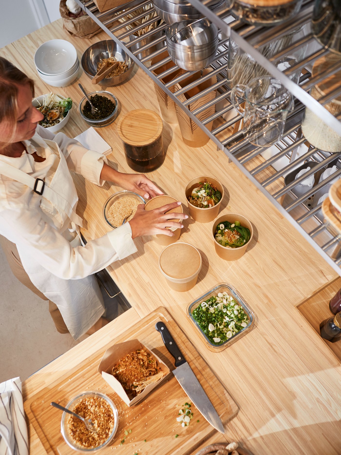 Woman cooking in a professional looking l shaped kitchen with a wood worktop