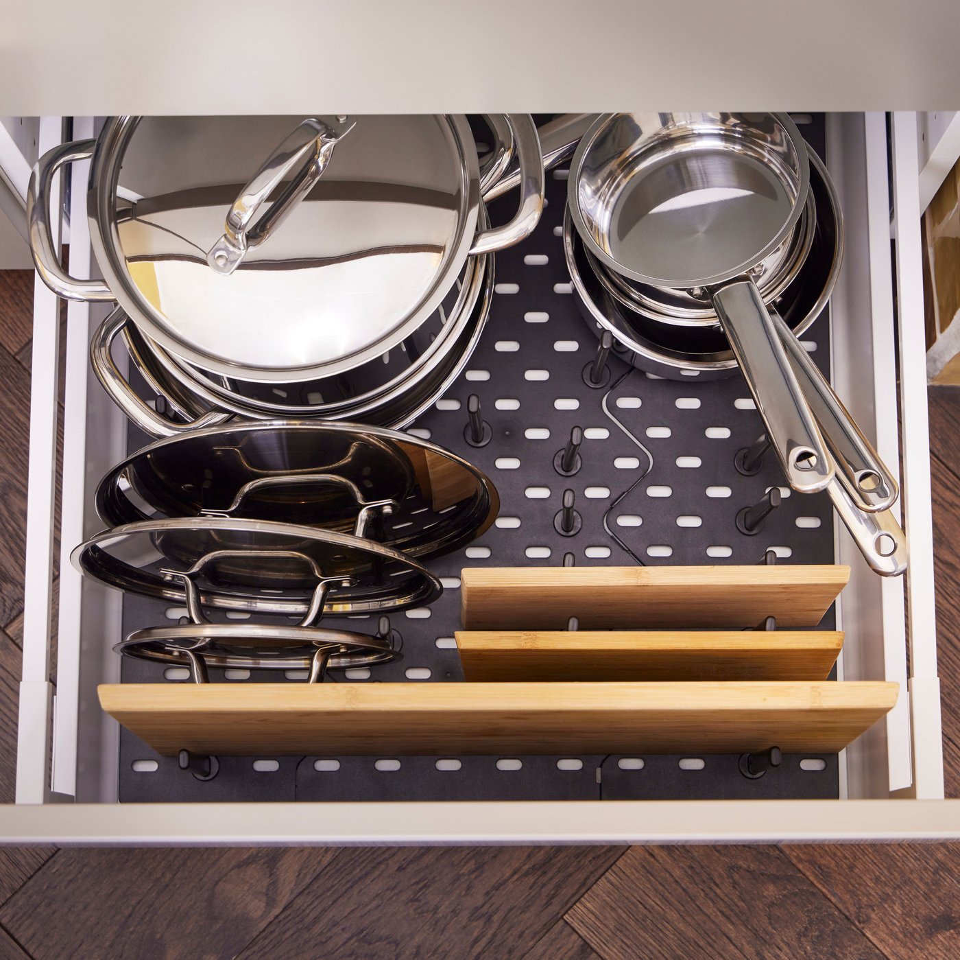 An UPPDATERA pegboard drawer organiser holds IKEA 365+ pots, saucepans and lids, plus three bamboo APTITLIG chopping boards.
