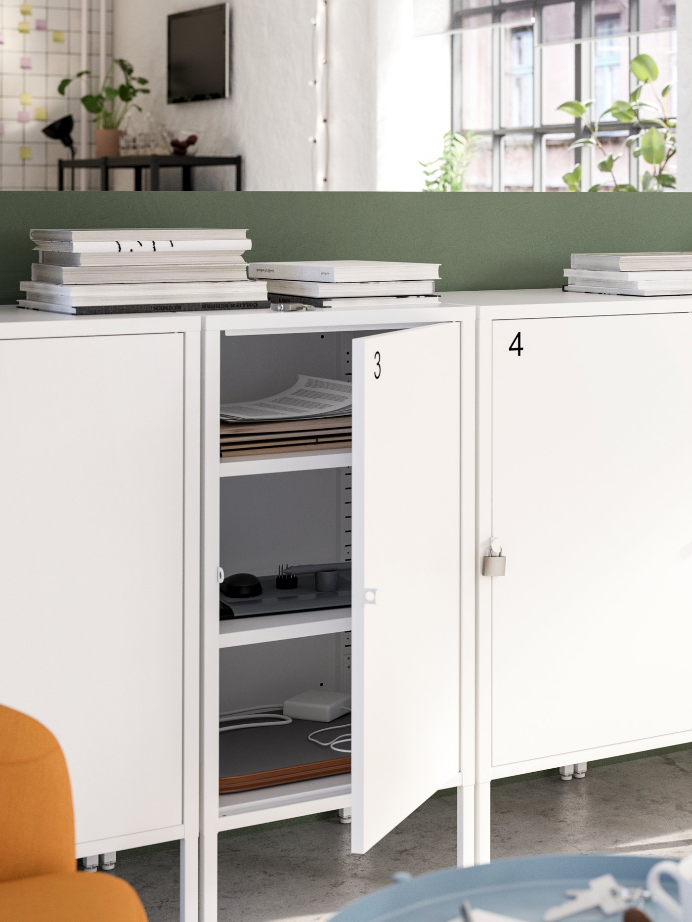 A row of white lockable cabinets with numbers on them, with one door is open showing papers and other items inside.