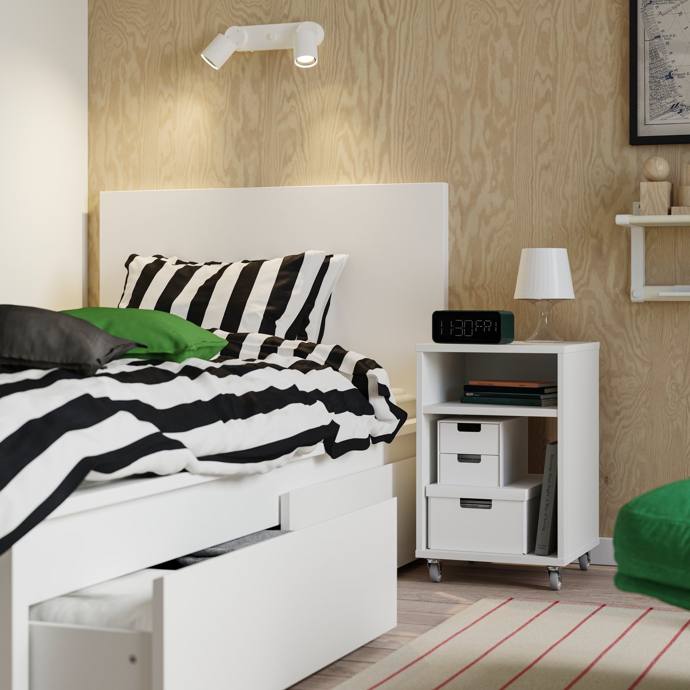 Base de cama MALM blanca con dos cajas de almacenamiento, una de ellas abierta con textiles en su interior.