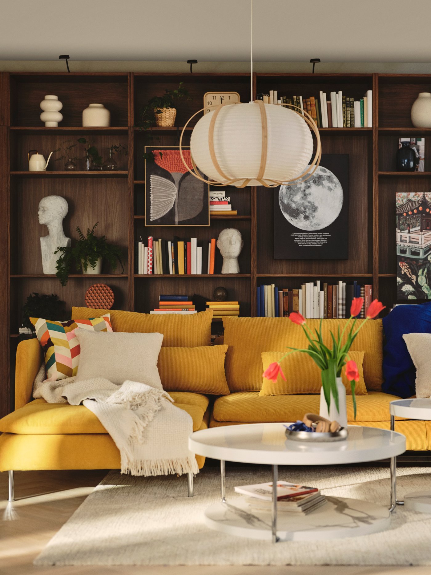 A living room features a dark yellow SÖDERHAMN 4-seat sofa-bed with chaise longue, beside a coffee table and vibrant décor.
