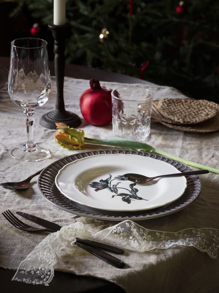 A traditional-looking table setting, with a white UPPLAGA plate at the centre layered on top of a blue plate.