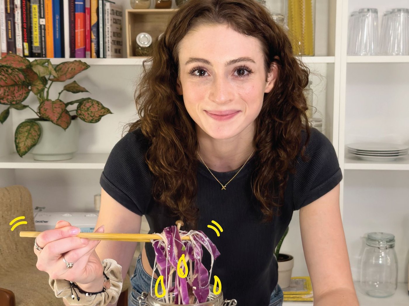 A woman posing in front of a glass jar filled with chopped vegetables.
