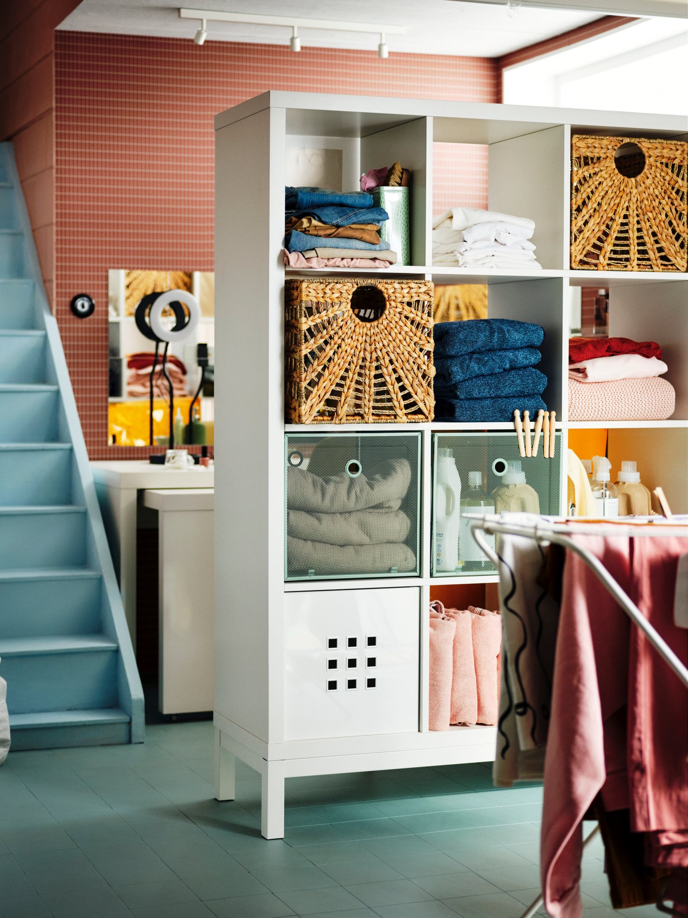 A white KALLAX shelving unit in the laundry room