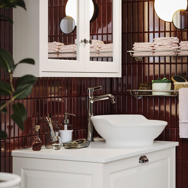 Salle de bain moderne avec mitigeur pour lavabo VOXNAN, meuble lavabo blanc, carrelage rouge foncé et meuble à miroir.