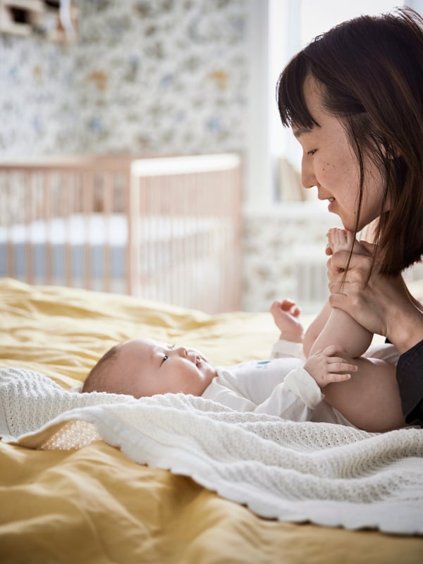 Un lit bébé SNIGLAR en hêtre dans la chambre d'enfant
