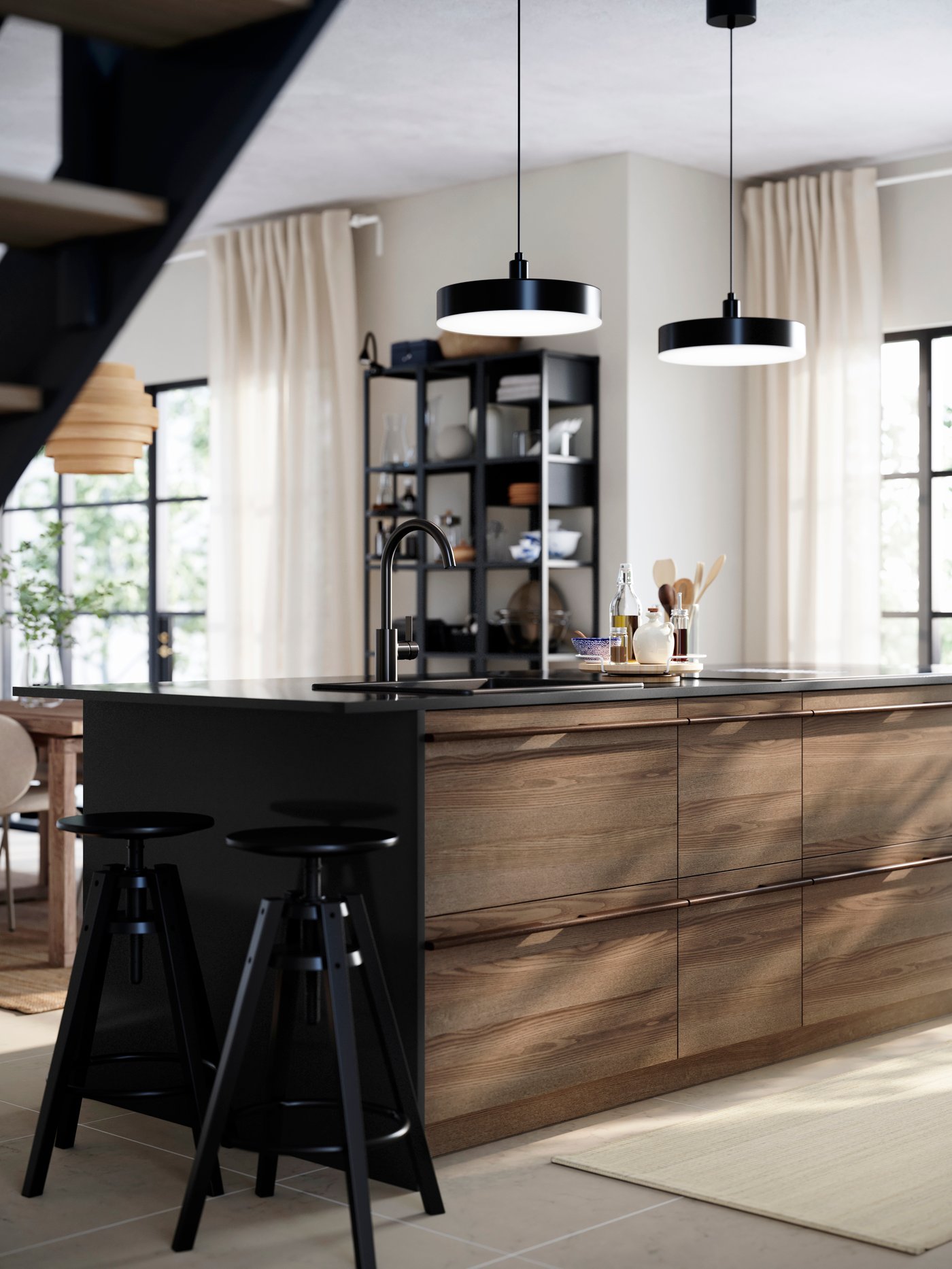 STENSTA dark ash veneer fronts highlight the island in a bright kitchen, complemented by tall stools and large windows.
