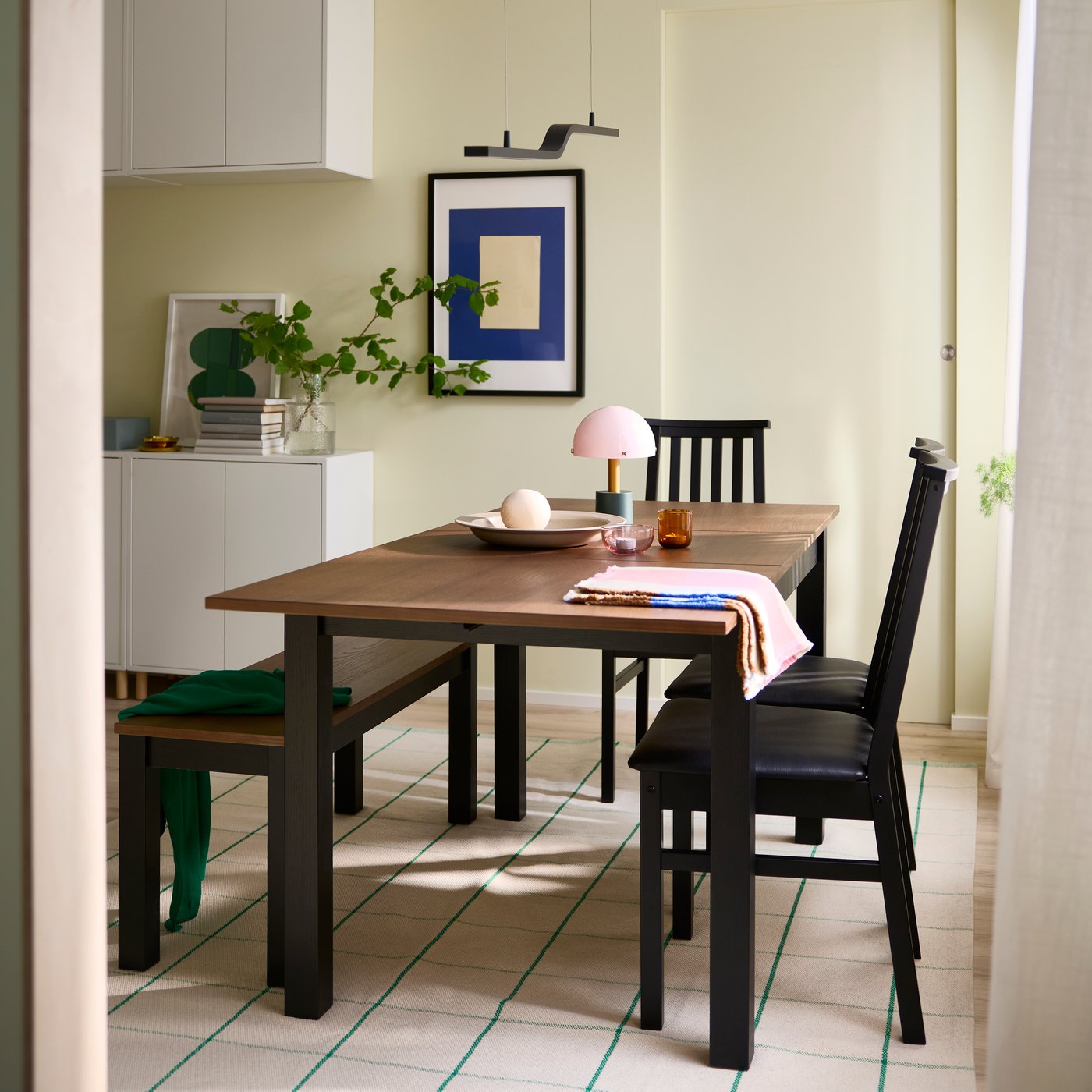 Mesa extensible ÅLHULT de 120/170 × 80 cm en negro y marrón, adaptable para distintas necesidades de comedor.