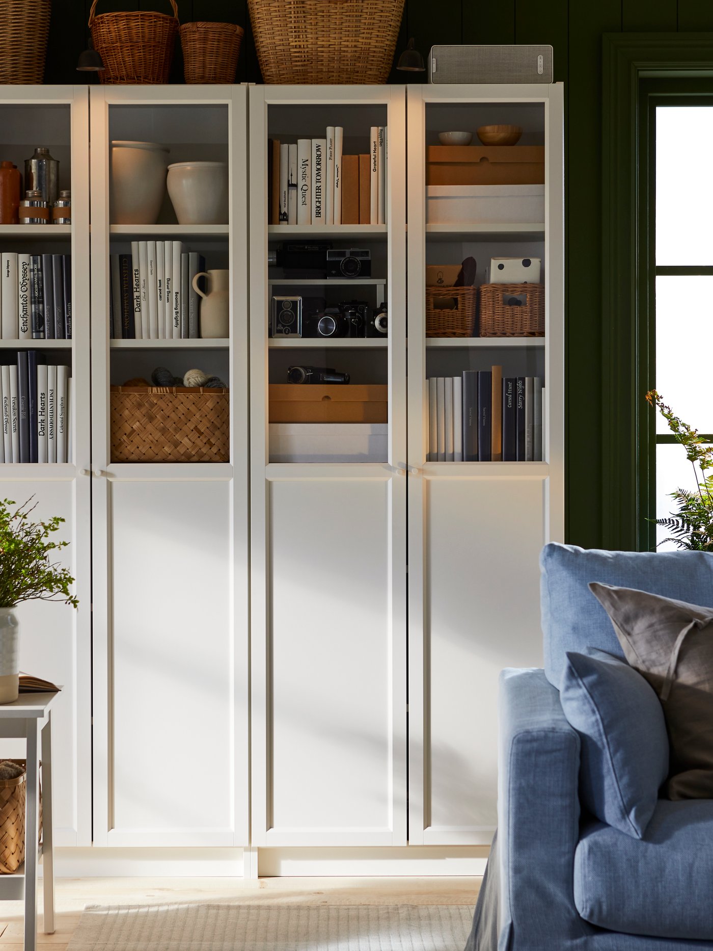 BILLY bookshelves in white with half glass doors in a living room setting.
