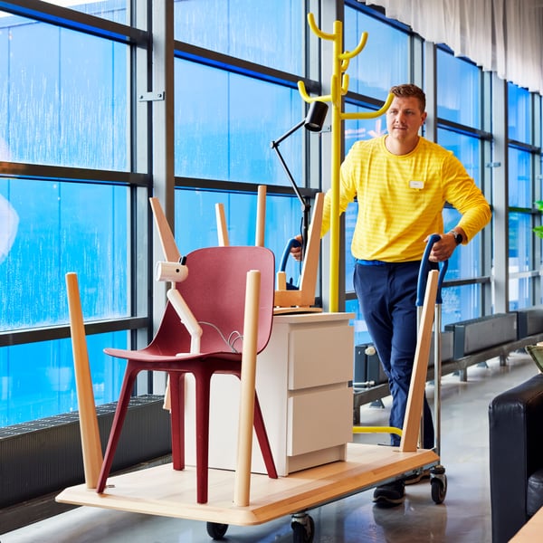 IKEA zaposleni gura kolica za kupovinu s nameštajem na odeljenje za zamenu i vraćanje robe.