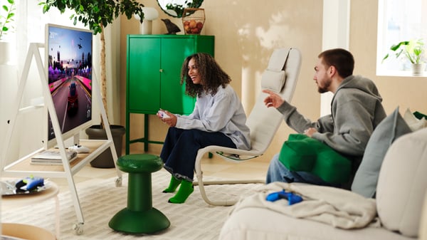 Two people are gaming on a white YXSTABY gaming TV stand on castors in the living room.