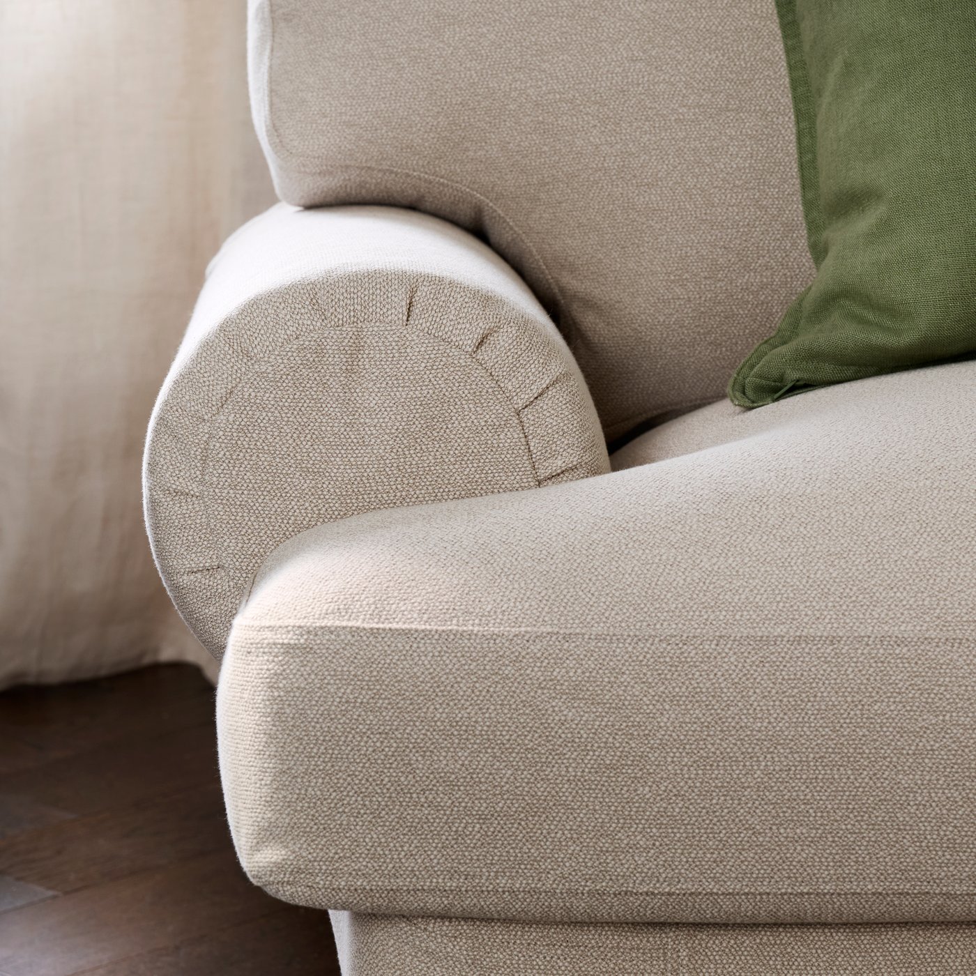 A close-up of the arm of a light beige VALNÄS 2-seat sofa made from Knäbäck fabric, showcasing its soft texture.