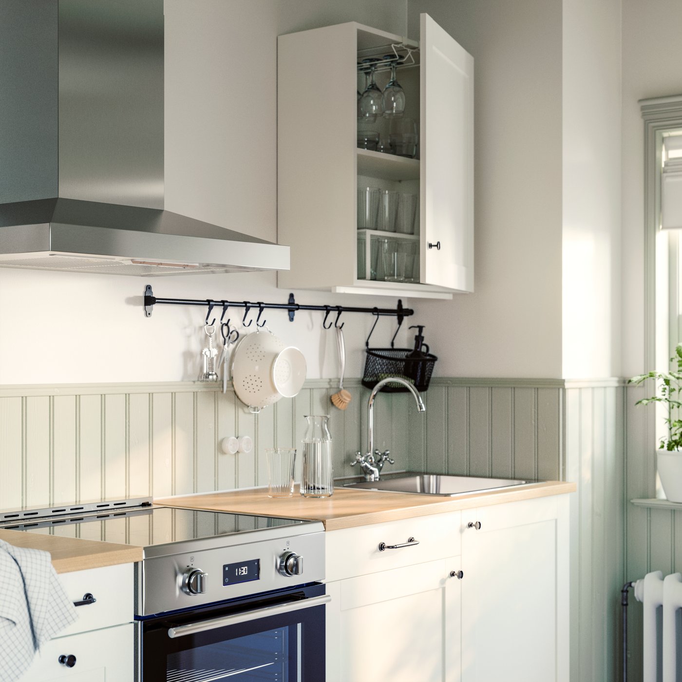 A small white KNOXHULT kitchen has an ÖRMINGE range with induction cooktop and a VINSTGIVANDE wall mounted extractor hood.