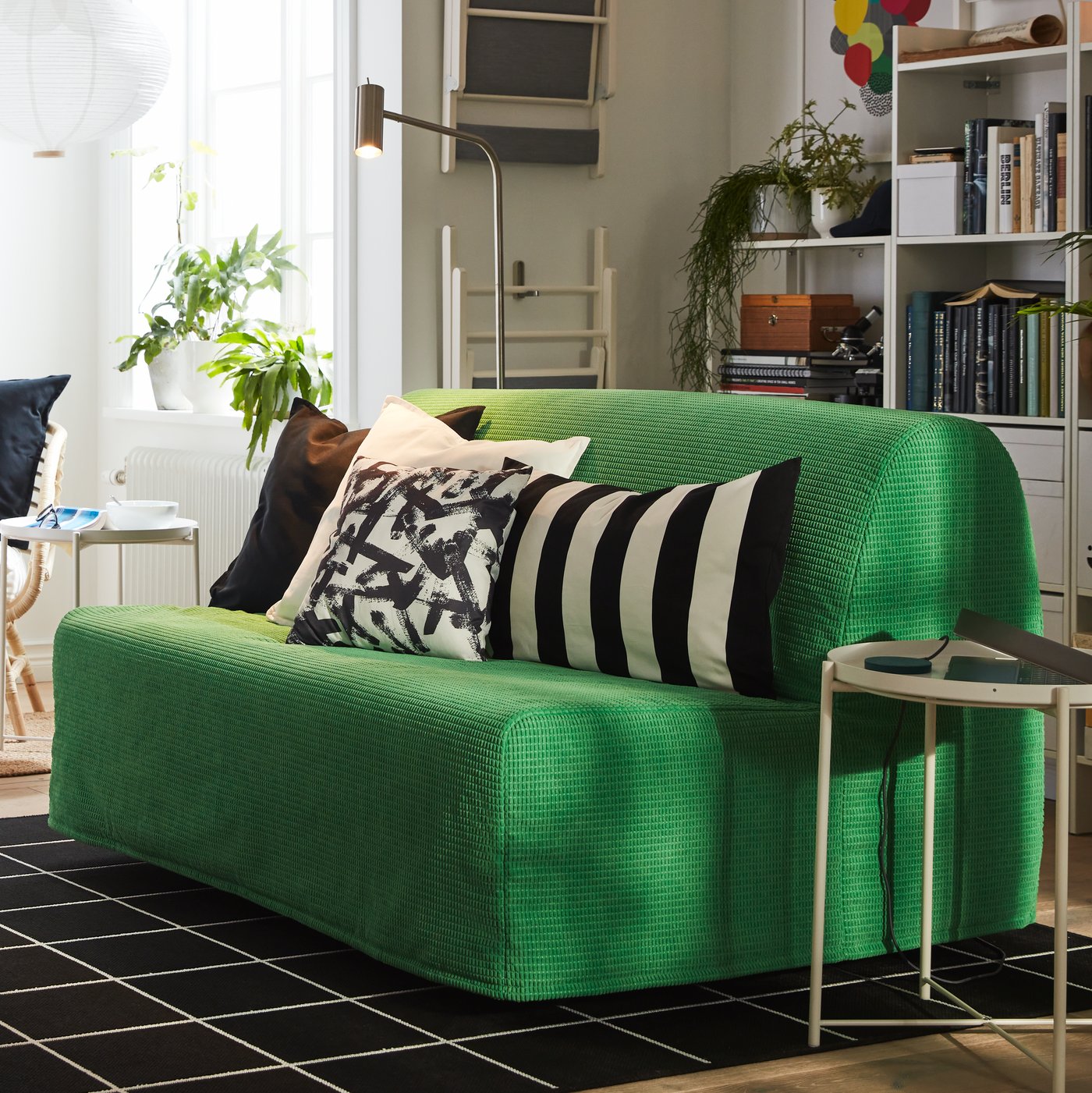 A small space witha green LYCKSELE LÖVÅS sofa-bed in the living room.