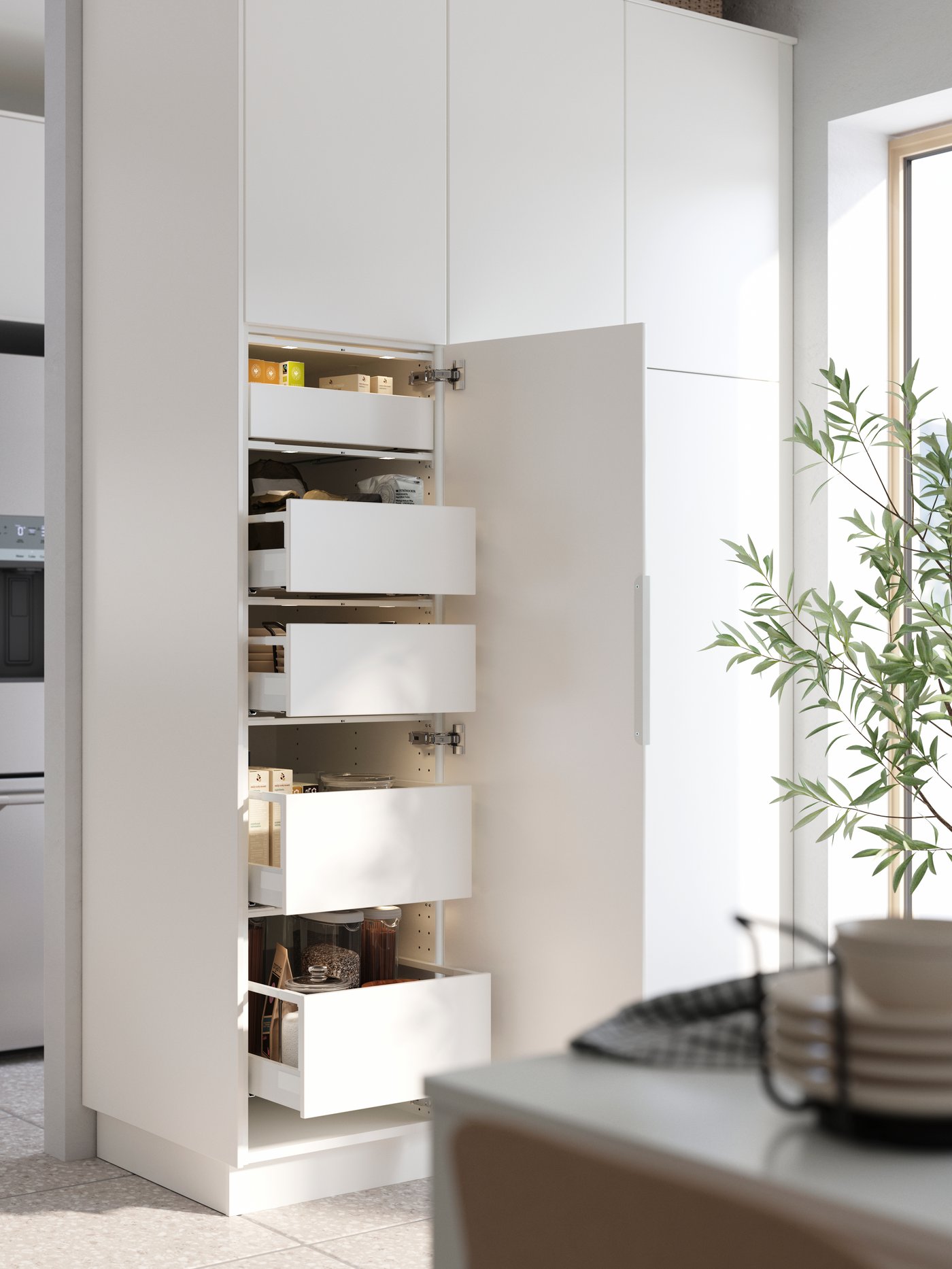 A kitchen features a white METOD pantry cabinet with open drawers displaying jars and food items, beautifully arranged