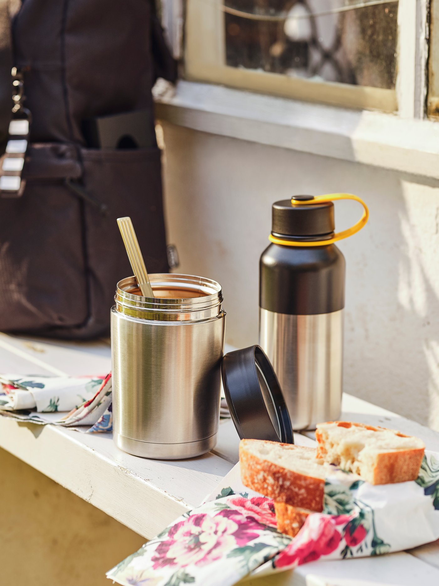 Food packed into food storage containers next to a flask