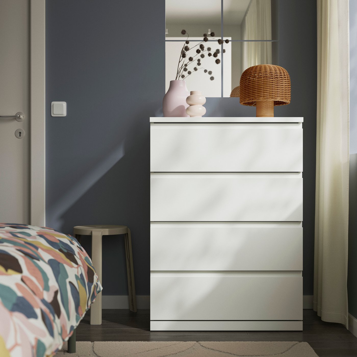 Eine weiße STORKLINTA Kommode mit vier Schubladen im Schlafzimmer