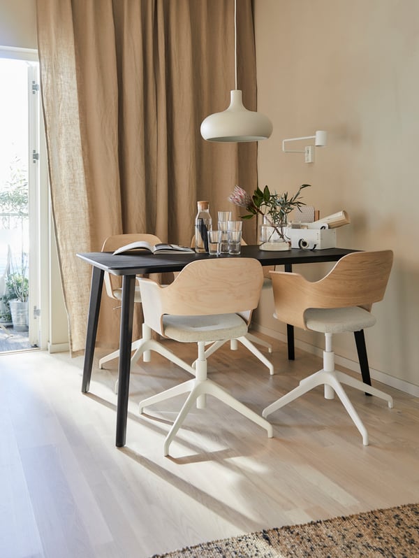 A black veneer table and four FJÄLLBERGET conference chairs with pale wooden backrests and light grey cushioned seats.