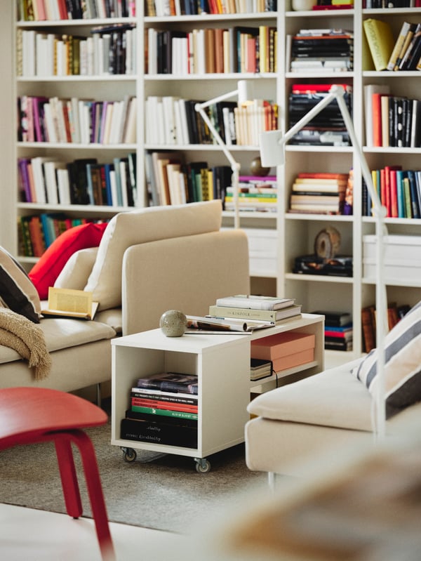 A living area with three Fridtuna light beige SÖDERHAMN 1-seat sections around a white VIHALS coffee table on a rug.