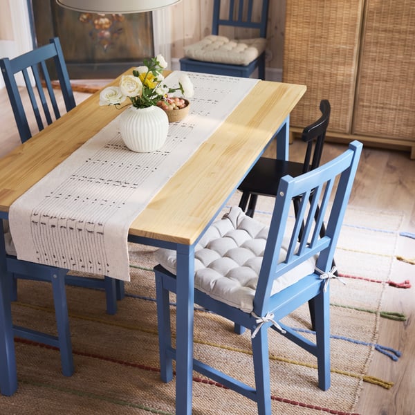 PINNTORP chairs with VIPPÄRT chair pads and an AGAM junior chair stand at a PINNTORP table with a VÅRARV table-runner.