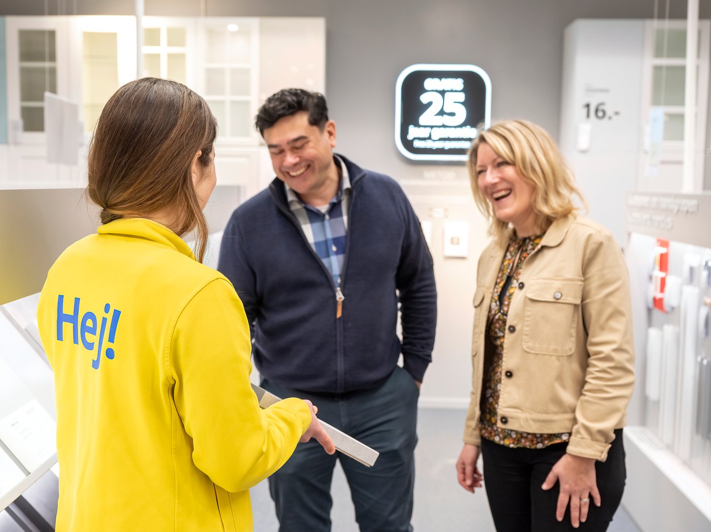 A couple looks at kitchen door fronts samples with an IKEA co-worker in the store