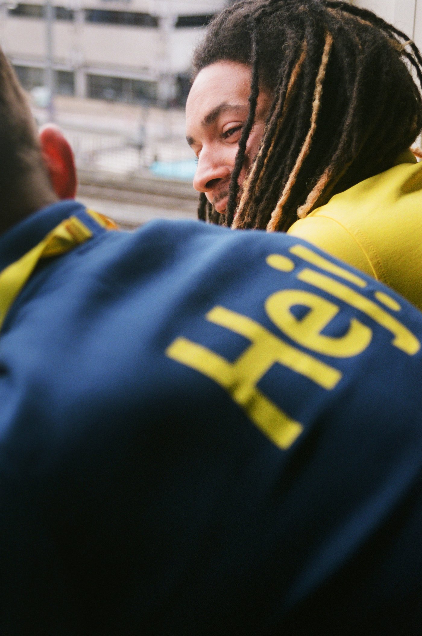 Twee IKEA medewerkers, een met dreadlocks, leunen voorover en doen een babbeltje.