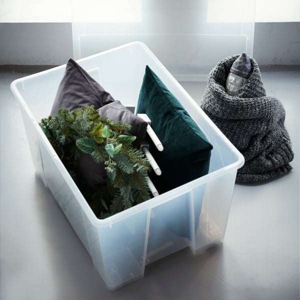 Du brauchst Aufbewahrungsideen für den Weihnachtsschmuck? Pack sie einfach in eine große Box. Weihnachtliche Textilien verwendest du als Polsterung. Bei IKEA findest du jede Menge Boxen wie z. B. SAMLA Box transparent, die obendrein sogar Rollen für bessere Beweglichkeit hat!