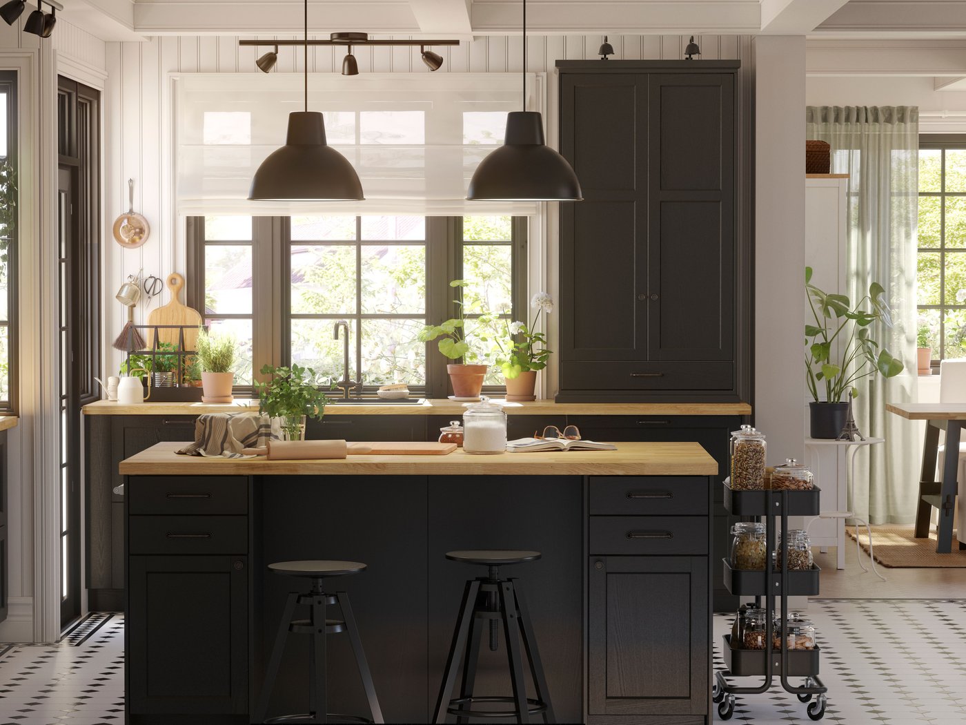 A large LERHYTTAN kitchen with black-stained fronts and a kitchen island in the center with two black pendant lamps above it.