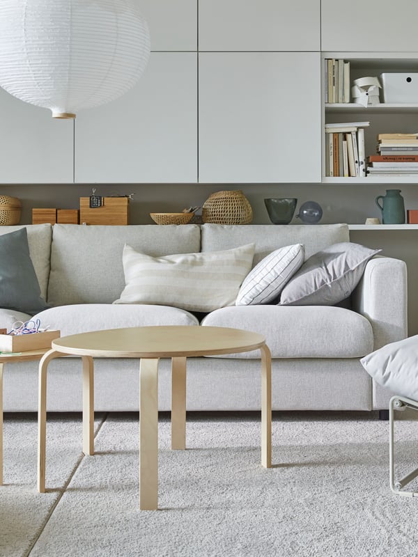 Ein helles Wohnzimmer im Scandi Chic mit einer bequemen beigen Sofa.