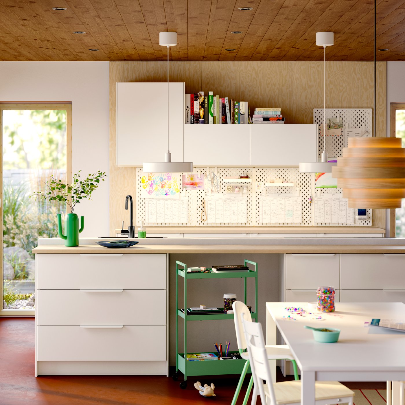 Rangement de cuisine avec portes VEDDINGE blanches et façades de tiroir, panneaux perforés SKÅDIS au mur et lampe suspendue.