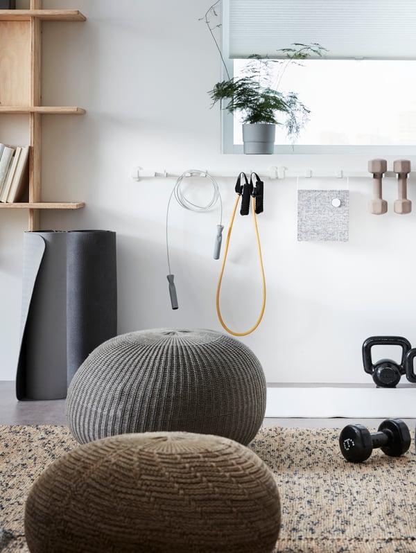 SANDARED pouffes scattered in a relaxation area of an office, with a VAJERT white rail hung with sport equipment.