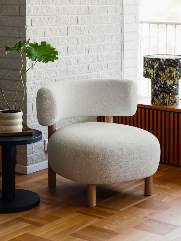 Un sillon beige STOCKHOLM 2025 super acolchado sobre un piso de madera en una sala moderna.
