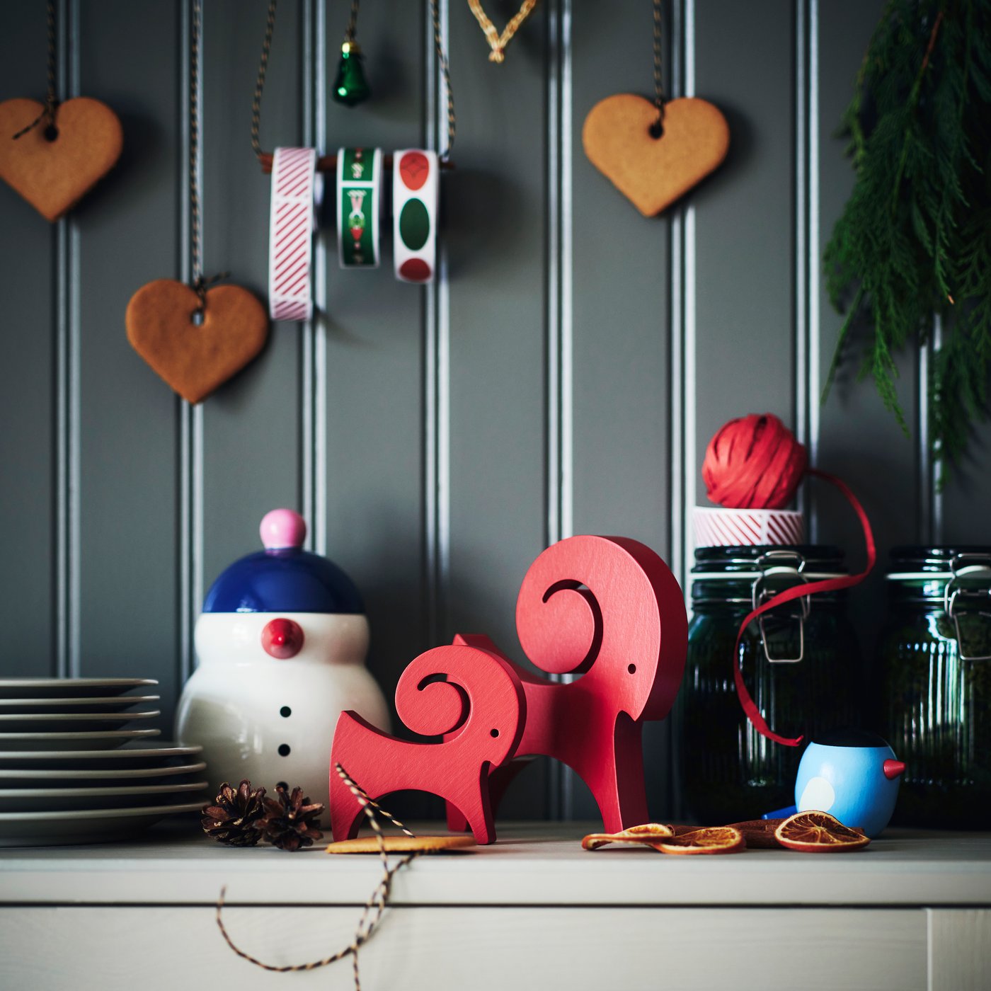 Two red VINTERFINT goat decorations stand on a sideboard alongside other festive decorations.