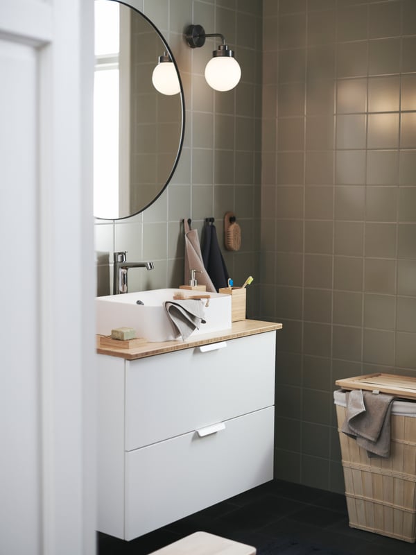 Une salle de bains avec une armoire de salle de bains GODMORGON/TOLKEN et un miroir LINDBYN sur le mur.
