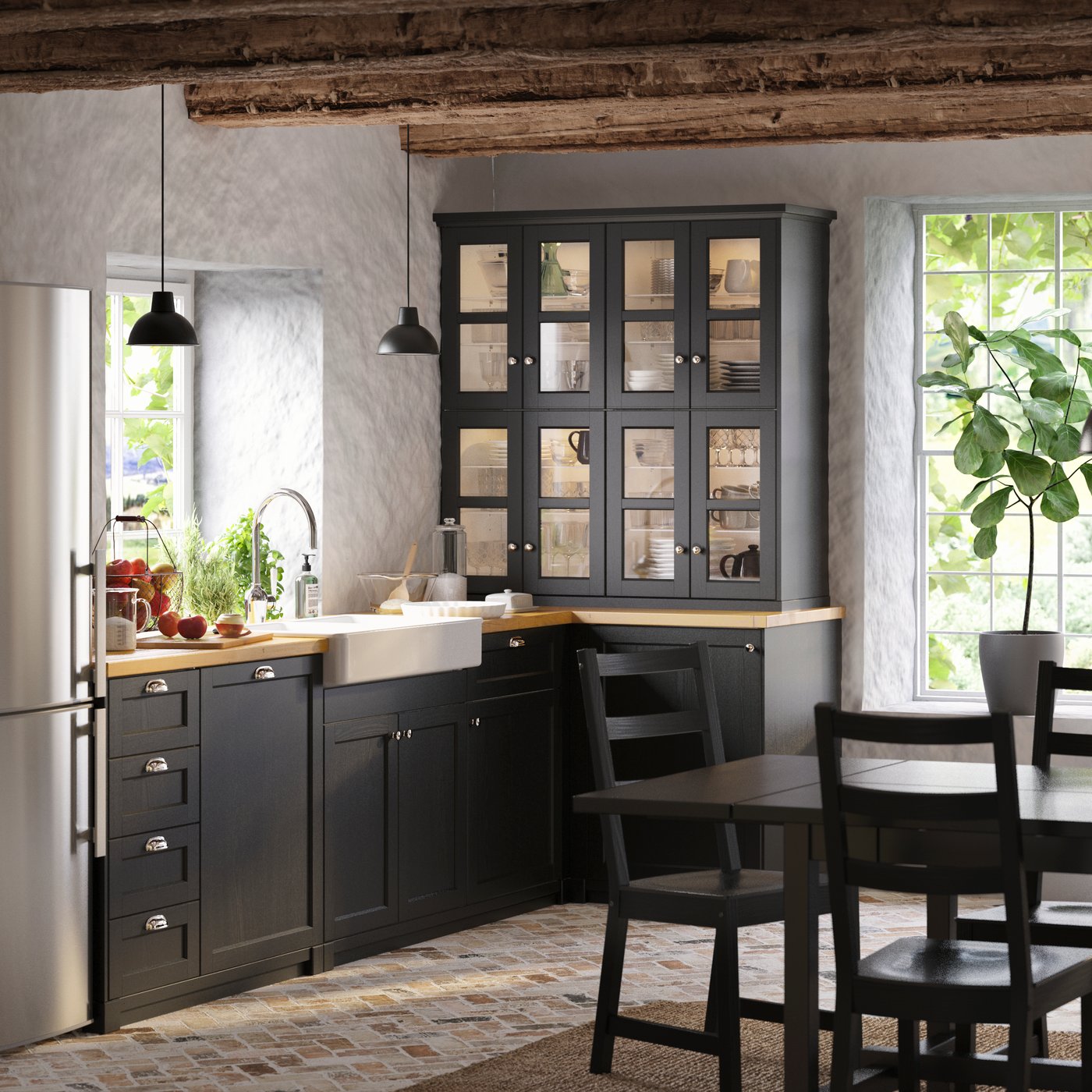 A country-style kitchen with black shaker LERHYTTAN kitchen fronts, a black extendable table and black chairs.