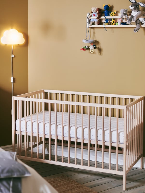 Una habitación infantil con una cuna SNIGLAR.