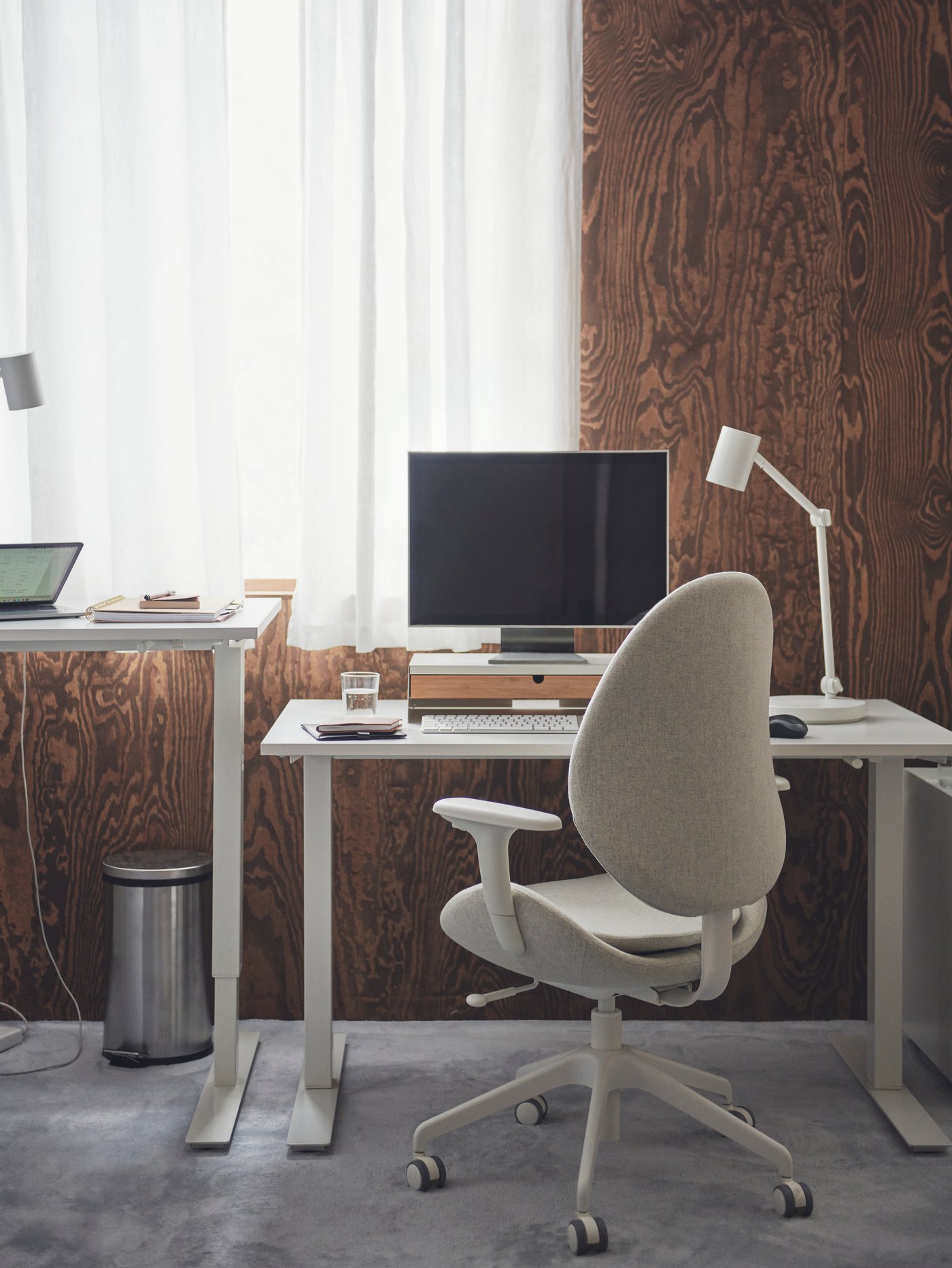 Een overzichtelijke werkplek voor het raam bestaat uit een wit TROTTEN zit-sta-bureau en een HATTEFJÄLL bureaustoel.