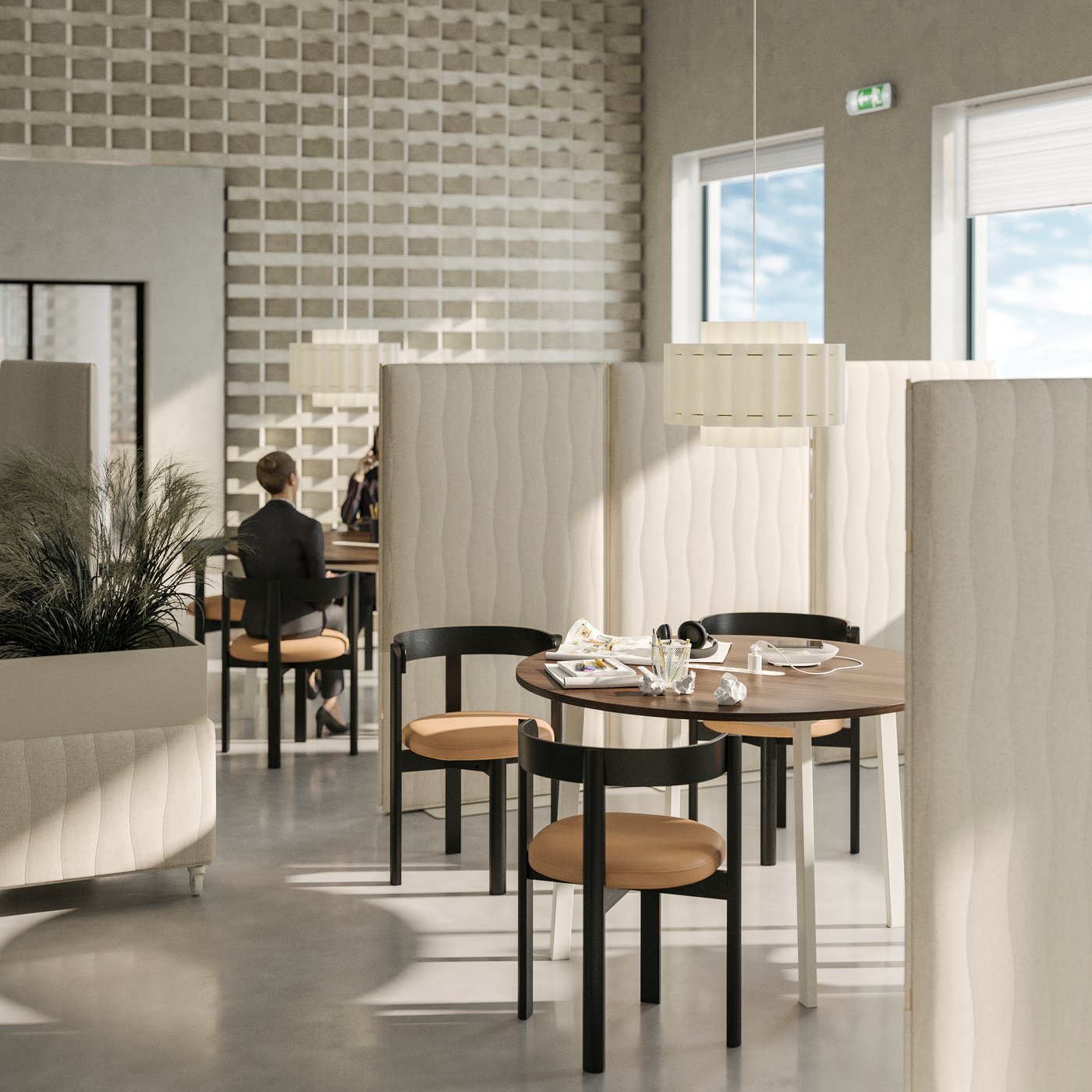 A breakout area for more casual conversations. Groups of tables and chairs are separated by acoustic panels.