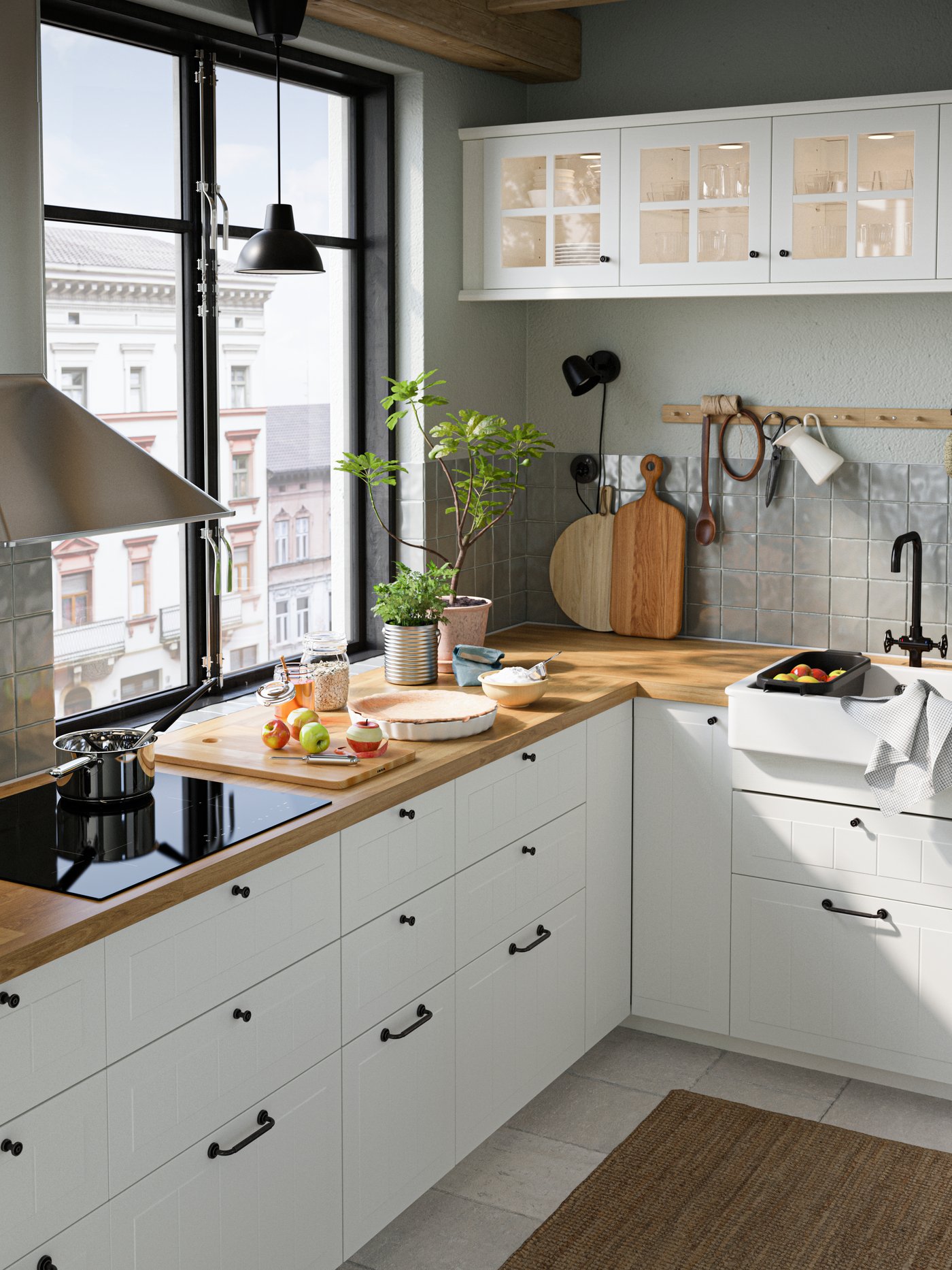 A kitchen with white drawer fronts and glass doors, oak effect SÄLJAN worktops, an induction hob and a black pendant lamp.