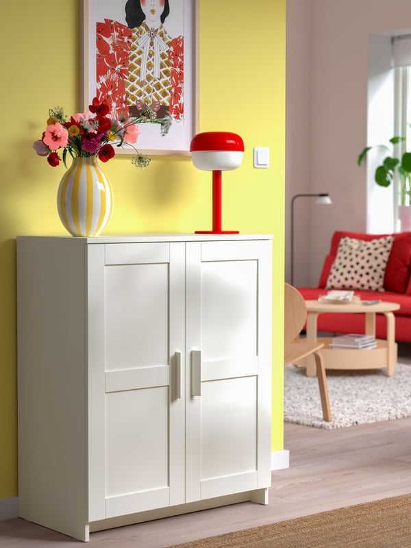 A red BLÅSVERK table lamp in the living room