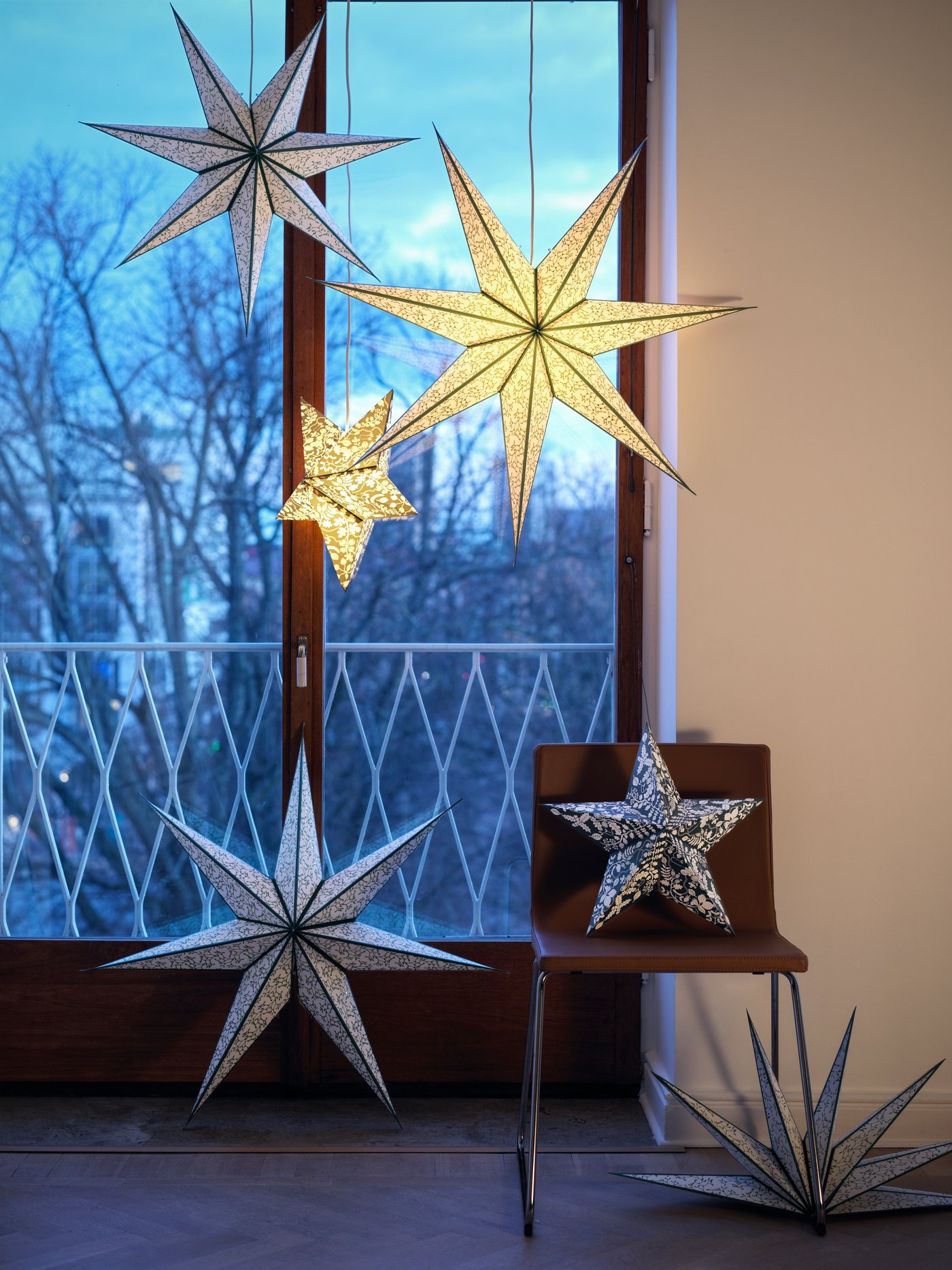 Una ventana con muchas lámparas colgantes en forma de estrella.